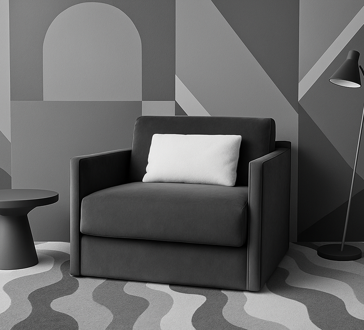 Moderner Sessel in Anthrazit mit weißem Kissen – minimalistisches Design trifft auf maximalen Komfort. Ideal für stilvolle Wohnräume mit grafischen Wandmustern.