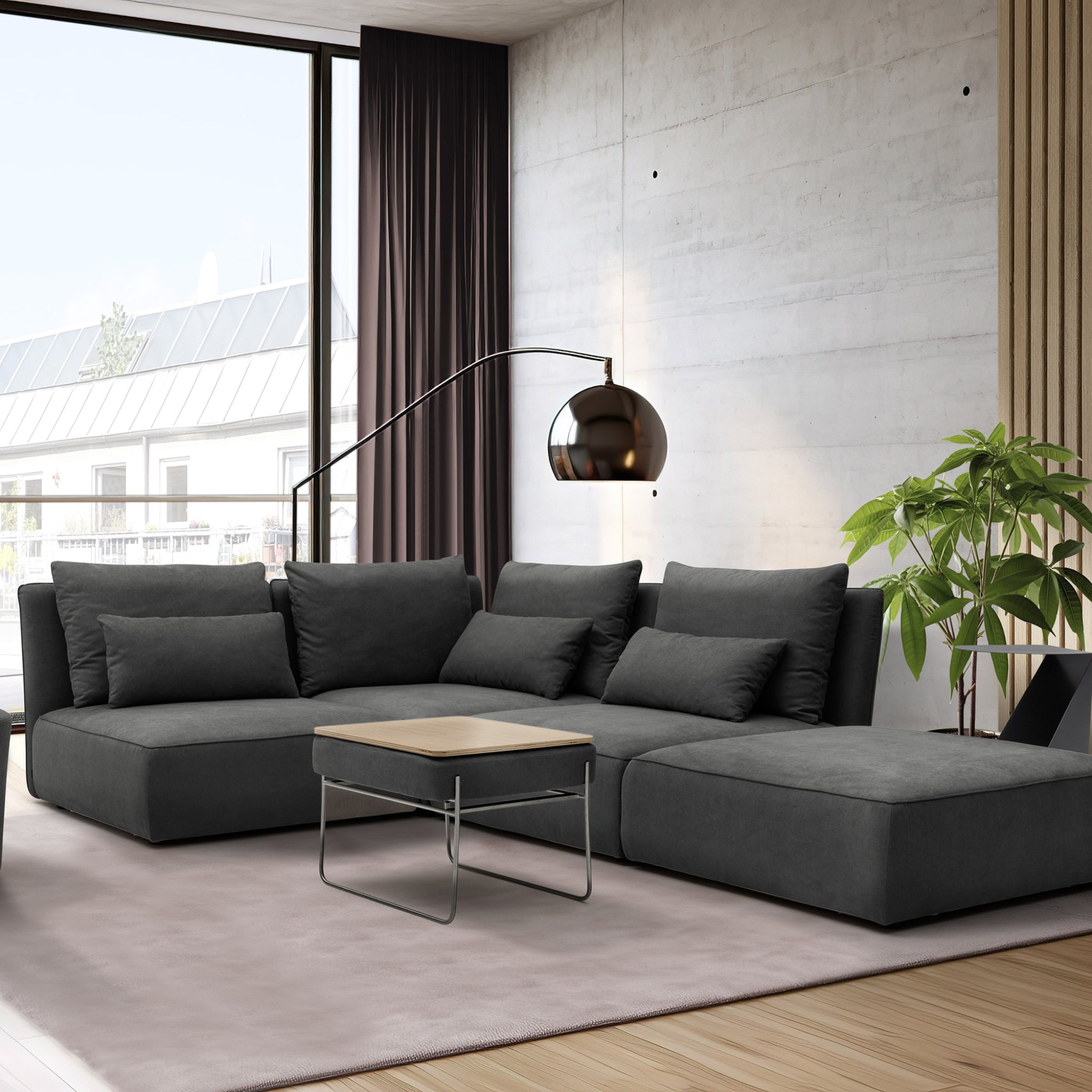 Modulares Sofa NICA Loungetime in der Farbe anthrazit. Das modulare Sofa steht auf einem rosafarbenen Teppich. Auf dem Teppich steht der Beistelltisch Propup. Hinter dem Sofa befindet sich eine Lampe und eine Pflanze.