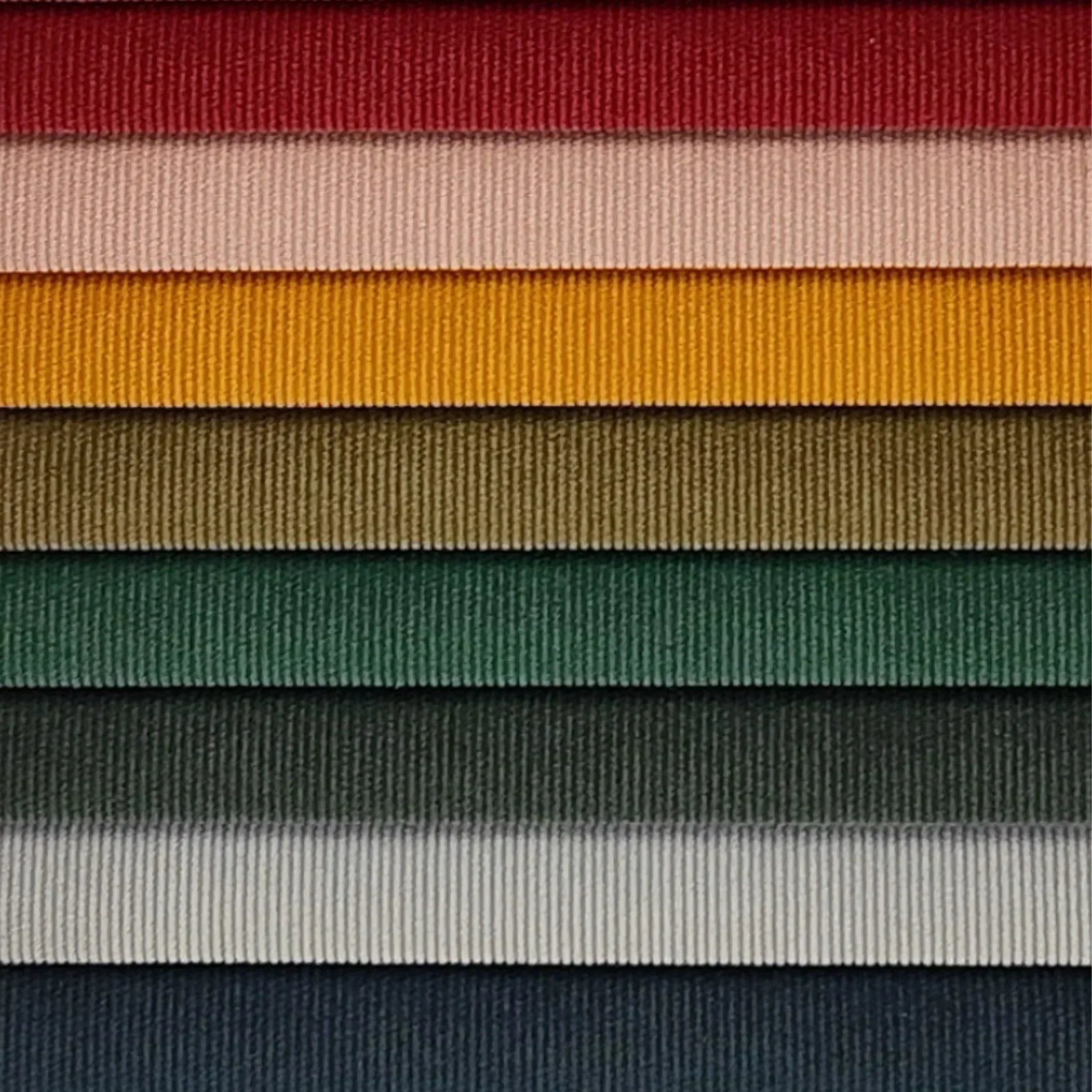 Nahaufnahme der Feincord-Stoffmuster von Yvi Living in verschiedenen Farben, darunter Rot, Rosé, Senfgelb, Olivgrün, Grasgrün, Anthrazit und Hellgrau – weicher, strukturierter Stoff mit feiner Rippenoptik für hochwertige, modulare Sofas.